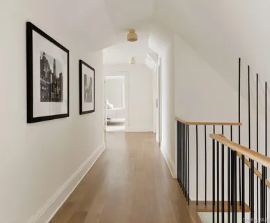 a view of a hallway with wooden floor and stairs