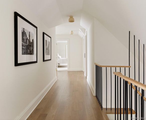 a view of a hallway with wooden floor and stairs