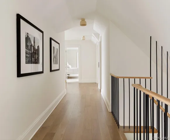 a view of a hallway with wooden floor and stairs