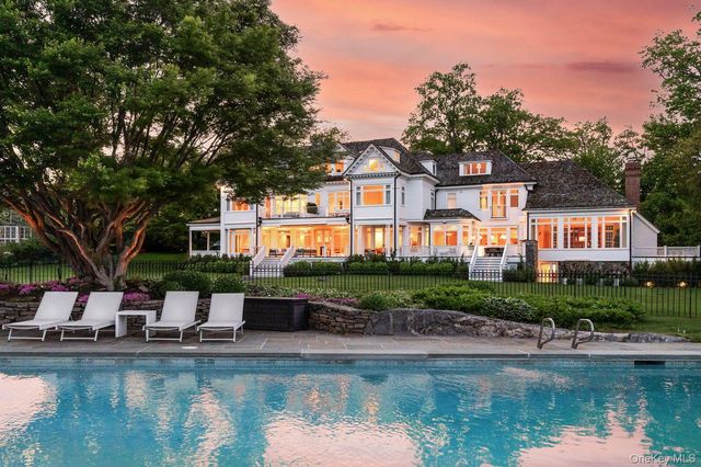 a front view of a house with swimming pool and a yard