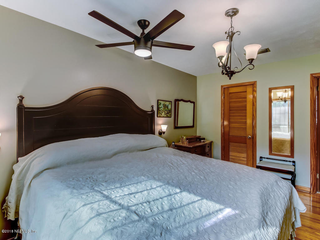 1321 Morgana Road Jacksonville, FL 32211 - Photo 20 of 44 a bedroom with a large bed and a chandelier