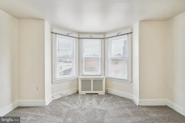 an empty room with windows and closet