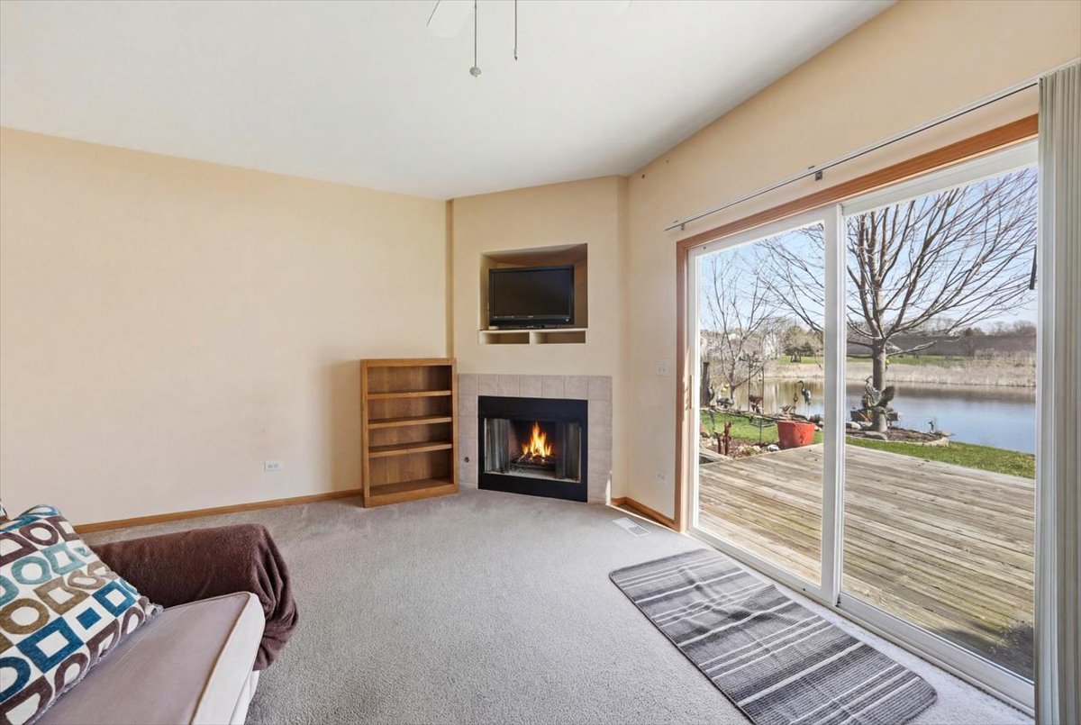 2542 Oak Tree Lane Plainfield, IL 60586 - Photo 5 of 20 a living room with furniture a flat screen tv and a fireplace