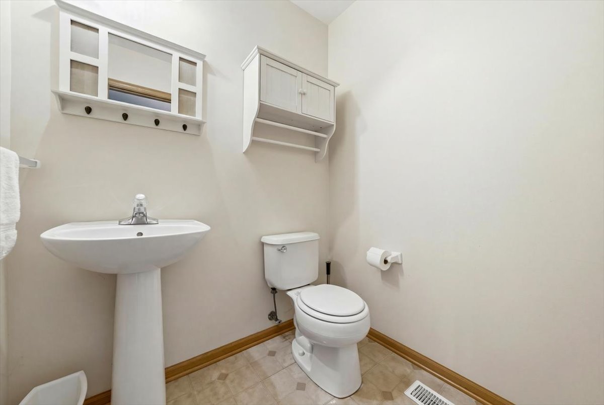 2542 Oak Tree Lane Plainfield, IL 60586 - Photo 10 of 20 a white toilet sitting next to a bathroom sink