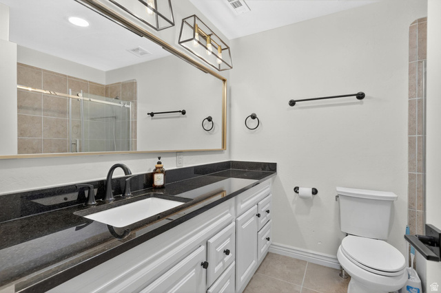 14738 Tangle Hill Road Herriman, UT 84096 - Photo 38 of 66 Bathroom vanity featuring a black countertop, white cabinetry with black hardware, and an undermount sink with a matte black faucet