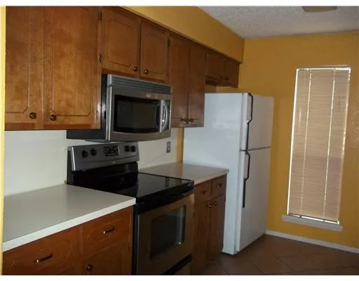 a kitchen with a sink a stove a refrigerator and cabinets
