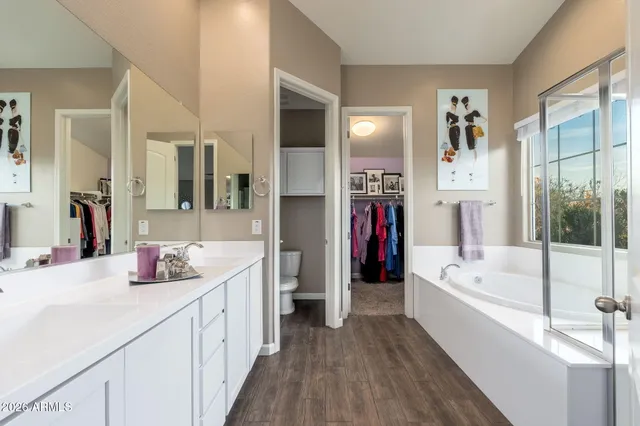 a bathroom with a tub a sink and a large mirror