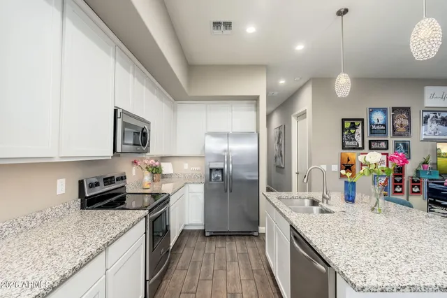a kitchen with stainless steel appliances granite countertop a sink refrigerator and microwave