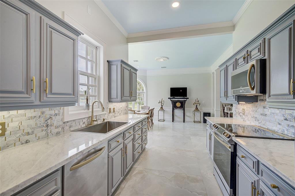75 Osprey Point Drive Osprey, FL 34229 - Photo 26 of 92 a kitchen with stainless steel appliances granite countertop a sink stove and cabinets