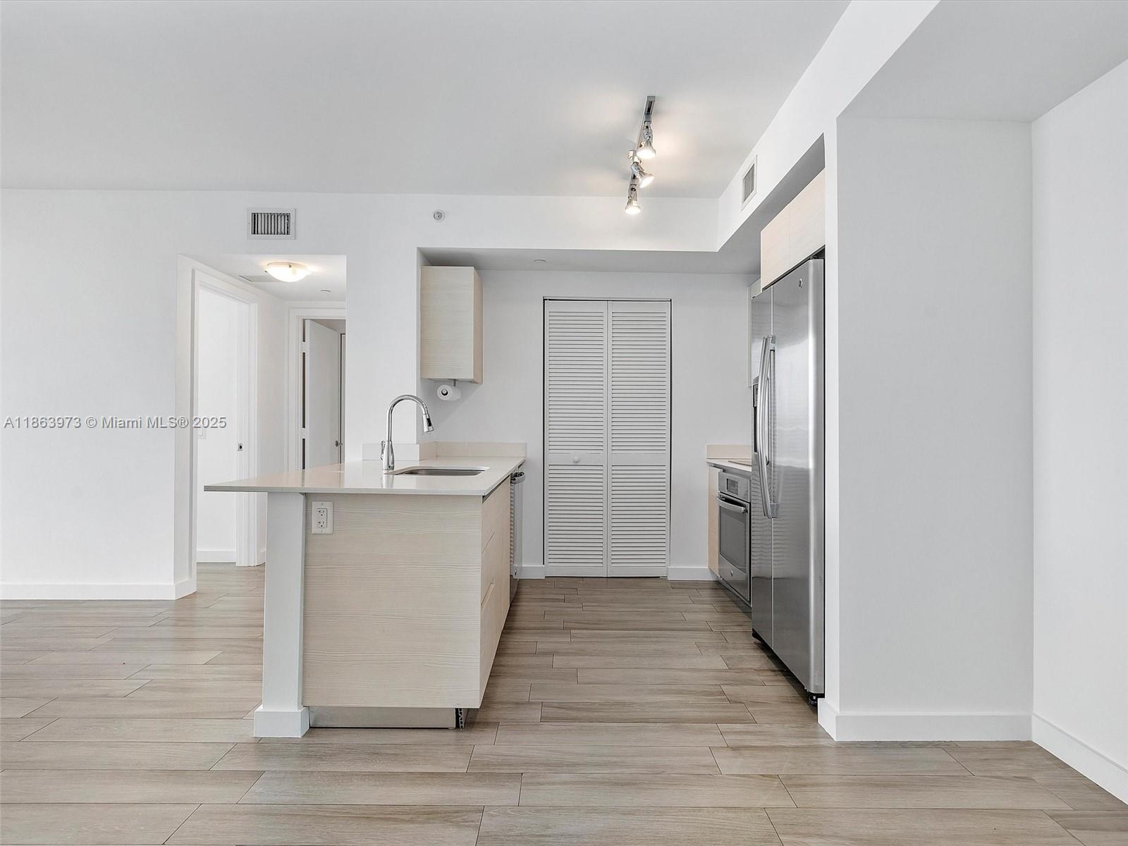 4250 Biscayne Boulevard, Unit 1416 Miami, FL 33137 - Photo 12 of 55 a kitchen with a refrigerator and a sink
