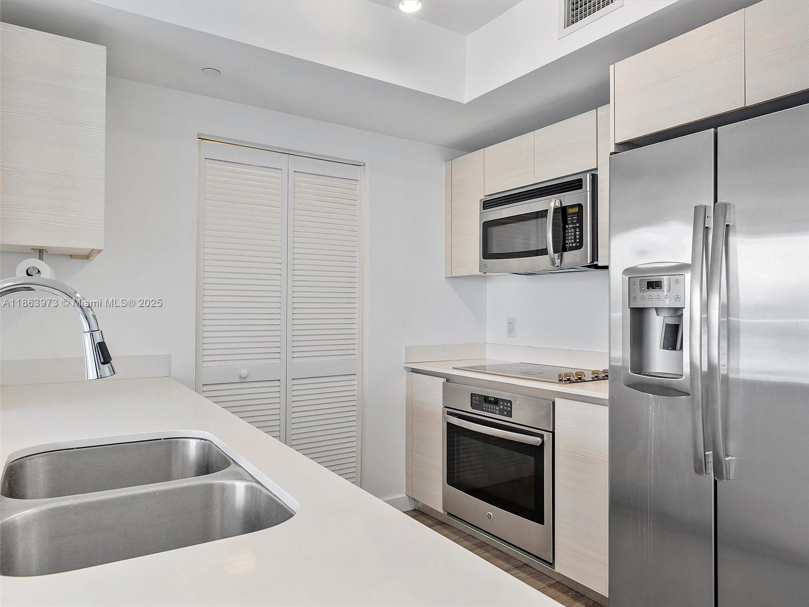 4250 Biscayne Boulevard, Unit 1416 Miami, FL 33137 - Photo 15 of 55 a kitchen with a sink stove and refrigerator
