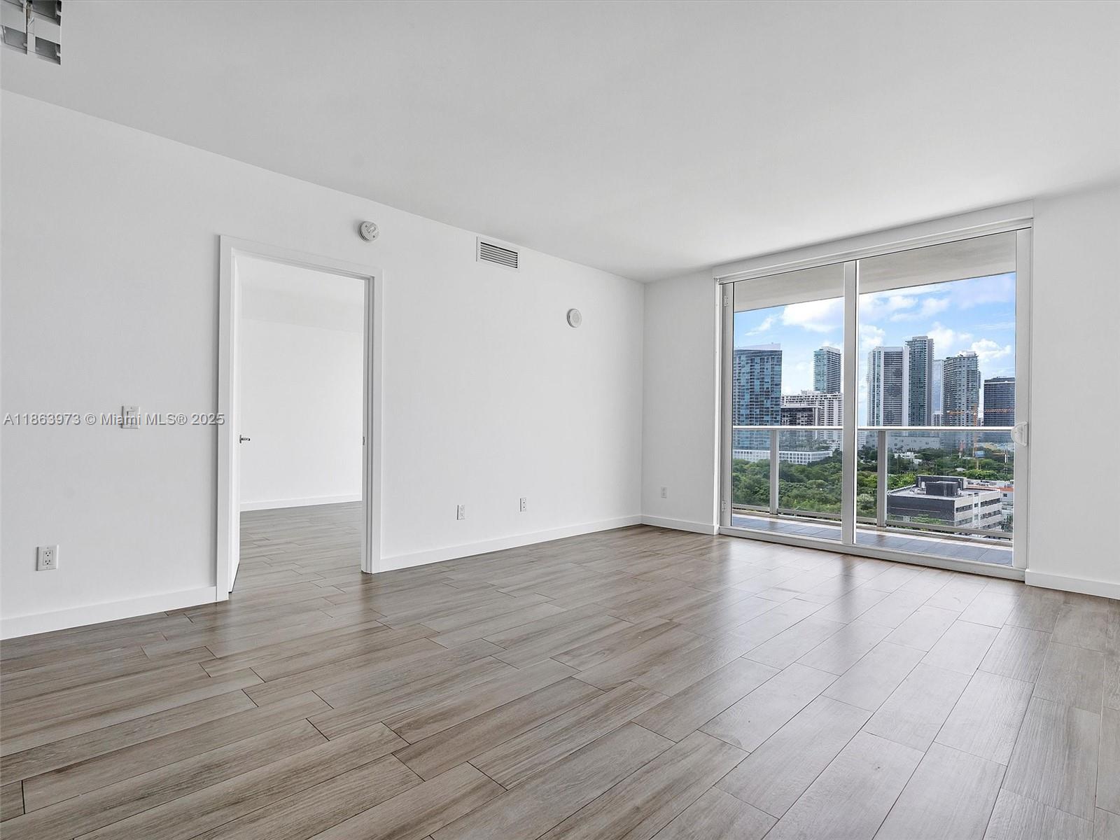 4250 Biscayne Boulevard, Unit 1416 Miami, FL 33137 - Photo 17 of 55 wooden floor in an empty room with a window