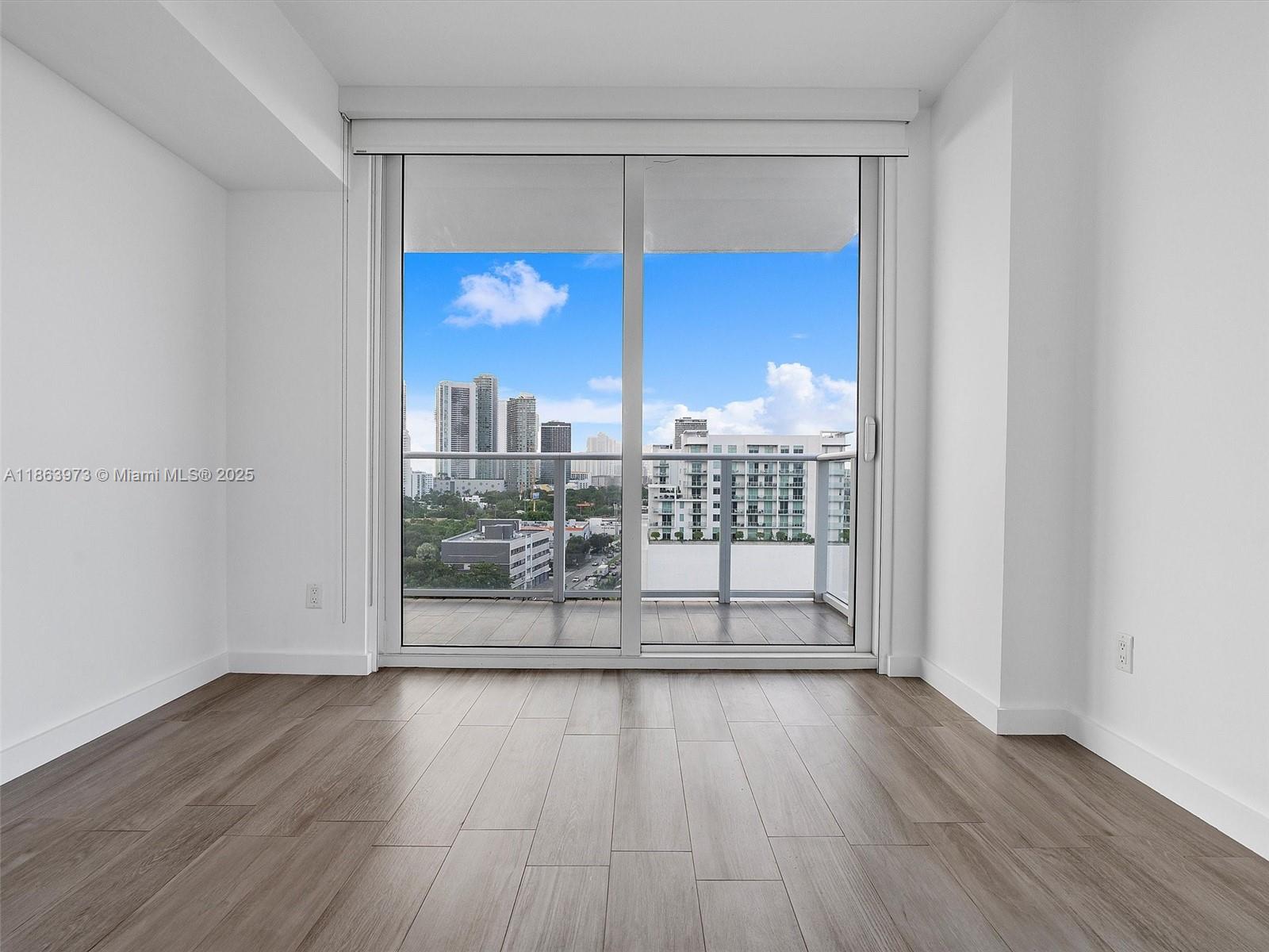 4250 Biscayne Boulevard, Unit 1416 Miami, FL 33137 - Photo 21 of 55 an empty room with wooden floor and windows