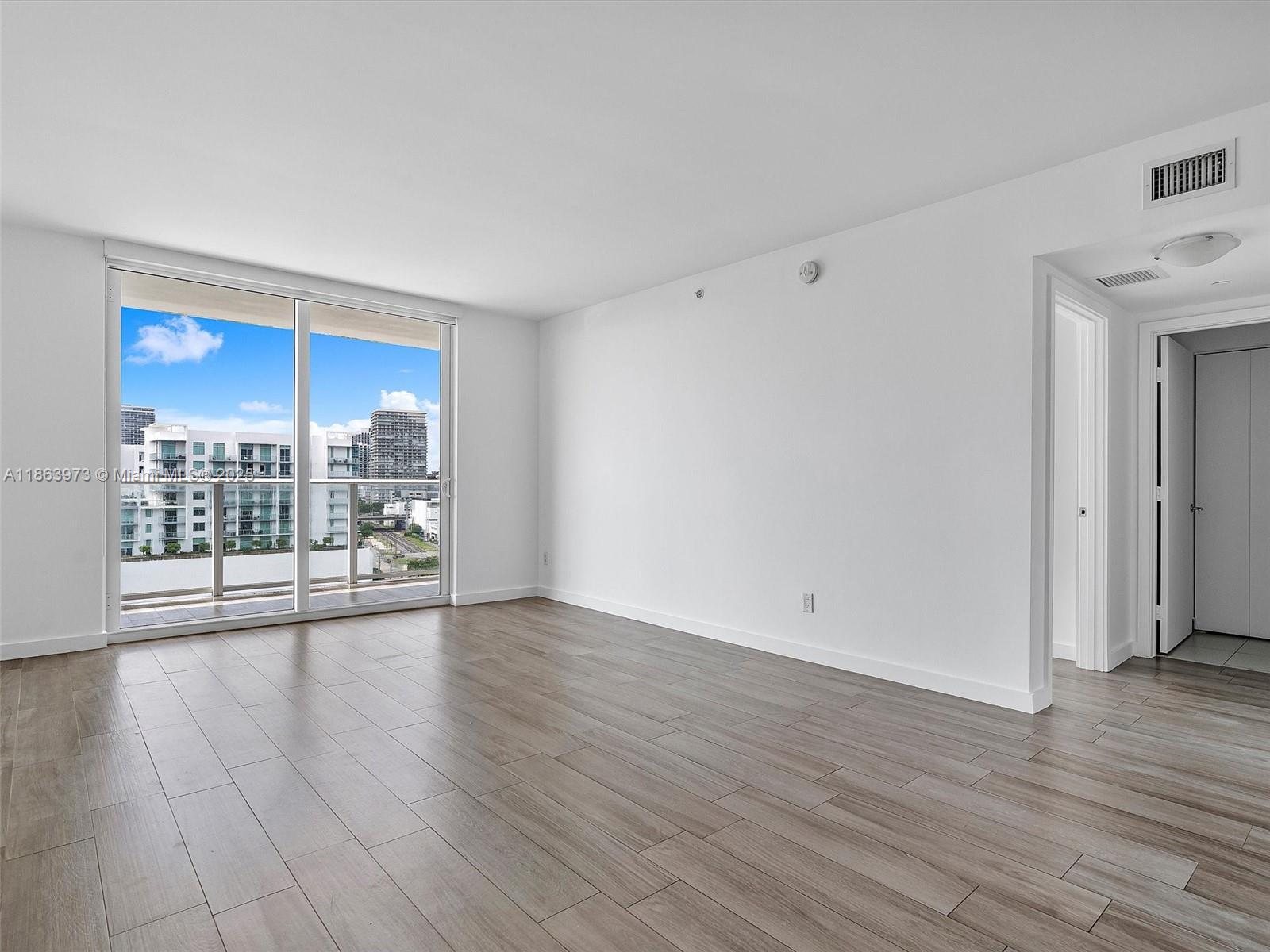 4250 Biscayne Boulevard, Unit 1416 Miami, FL 33137 - Photo 22 of 55 a view of an empty room with wooden floor and a window