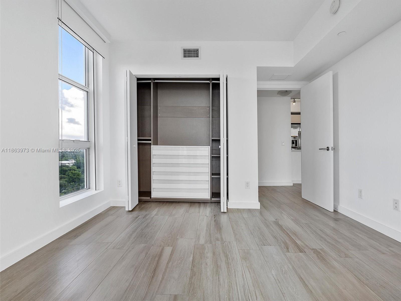 4250 Biscayne Boulevard, Unit 1416 Miami, FL 33137 - Photo 33 of 55 an empty room with wooden floor closet and windows