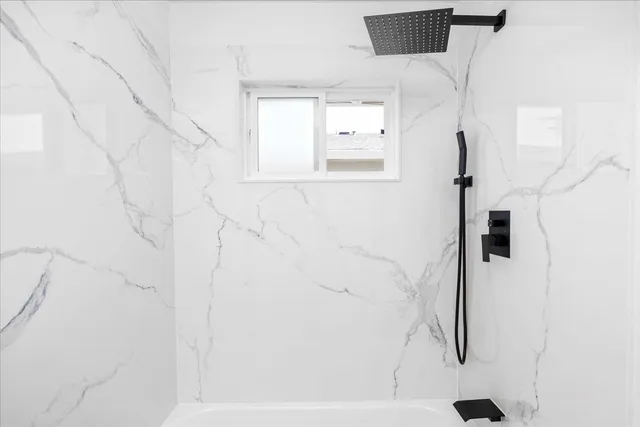 a bathroom with a bathtub and a shower