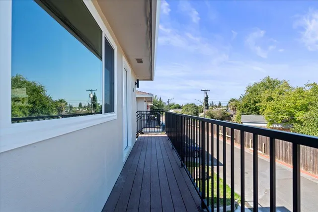 a view of a balcony with wooden floor and fence