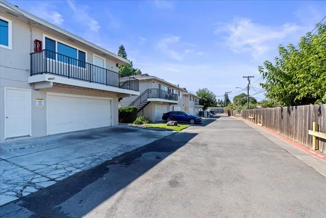 a view of a street with a house in the background