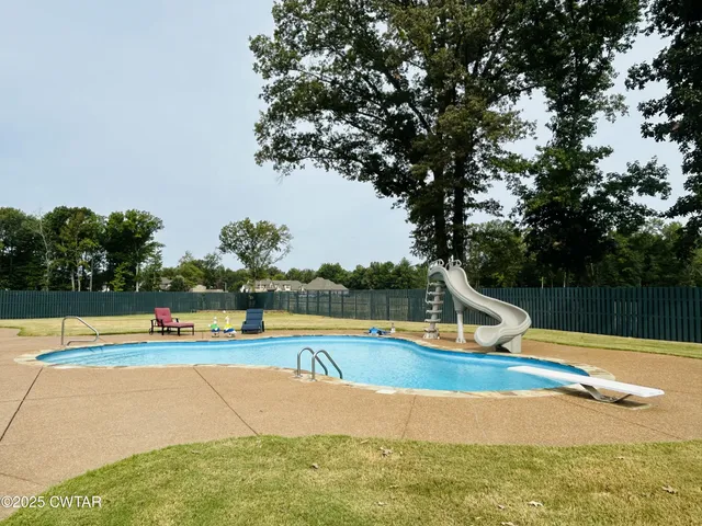 a view of a white house with a yard and sitting area