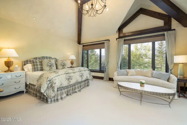 a bed sitting in a spacious bedroom next to a window