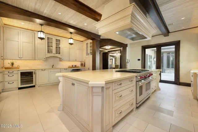 a large white kitchen with stainless steel appliances granite countertop a stove and a sink