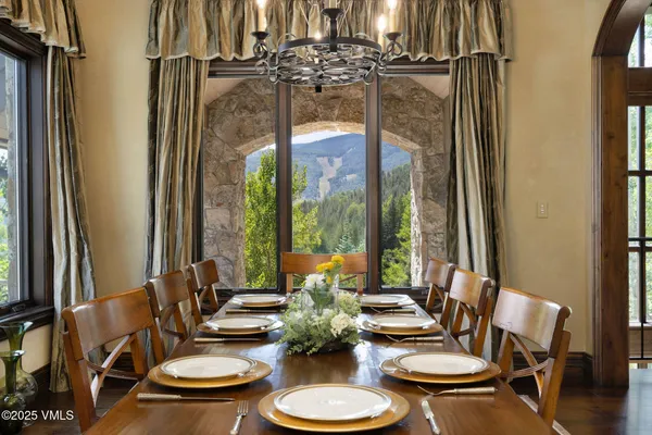 a dining room with furniture a chandelier and window