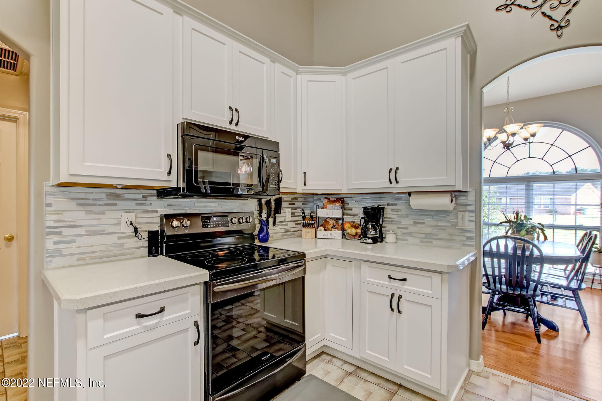 54025 Paddock Court Callahan, FL 32011 - Photo 16 of 47 a kitchen with granite countertop a stove a sink and a microwave