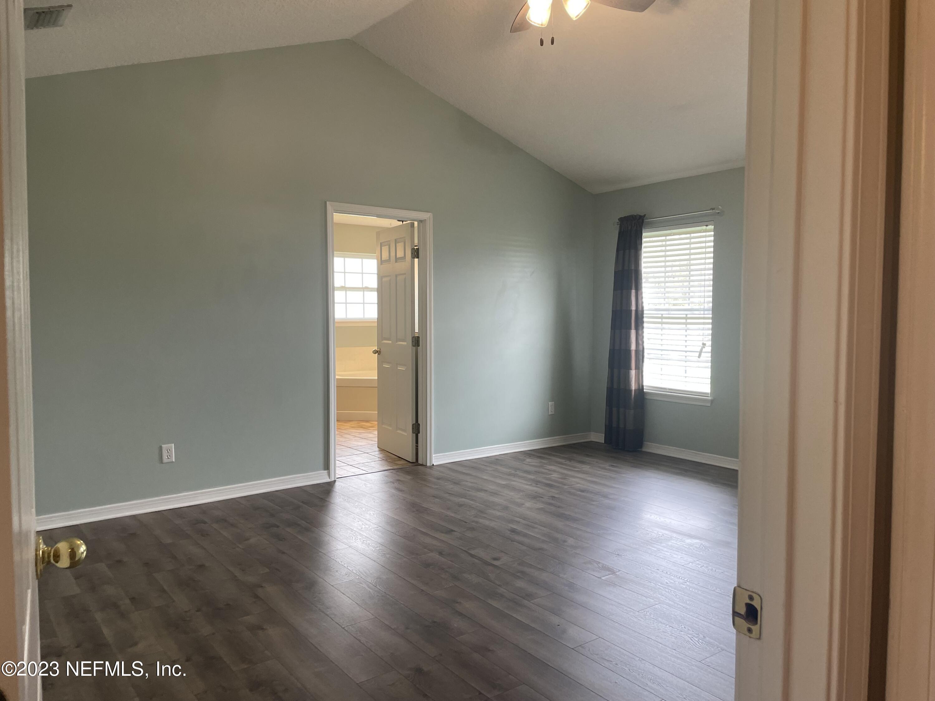54025 Paddock Court Callahan, FL 32011 - Photo 19 of 47 an empty room with wooden floor and windows