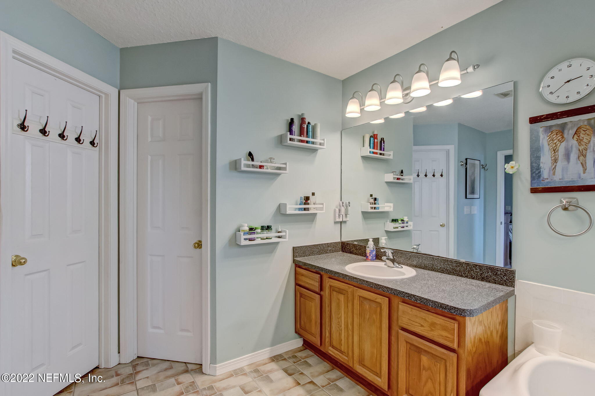 54025 Paddock Court Callahan, FL 32011 - Photo 22 of 47 a bathroom with a sink a large mirror and a shower