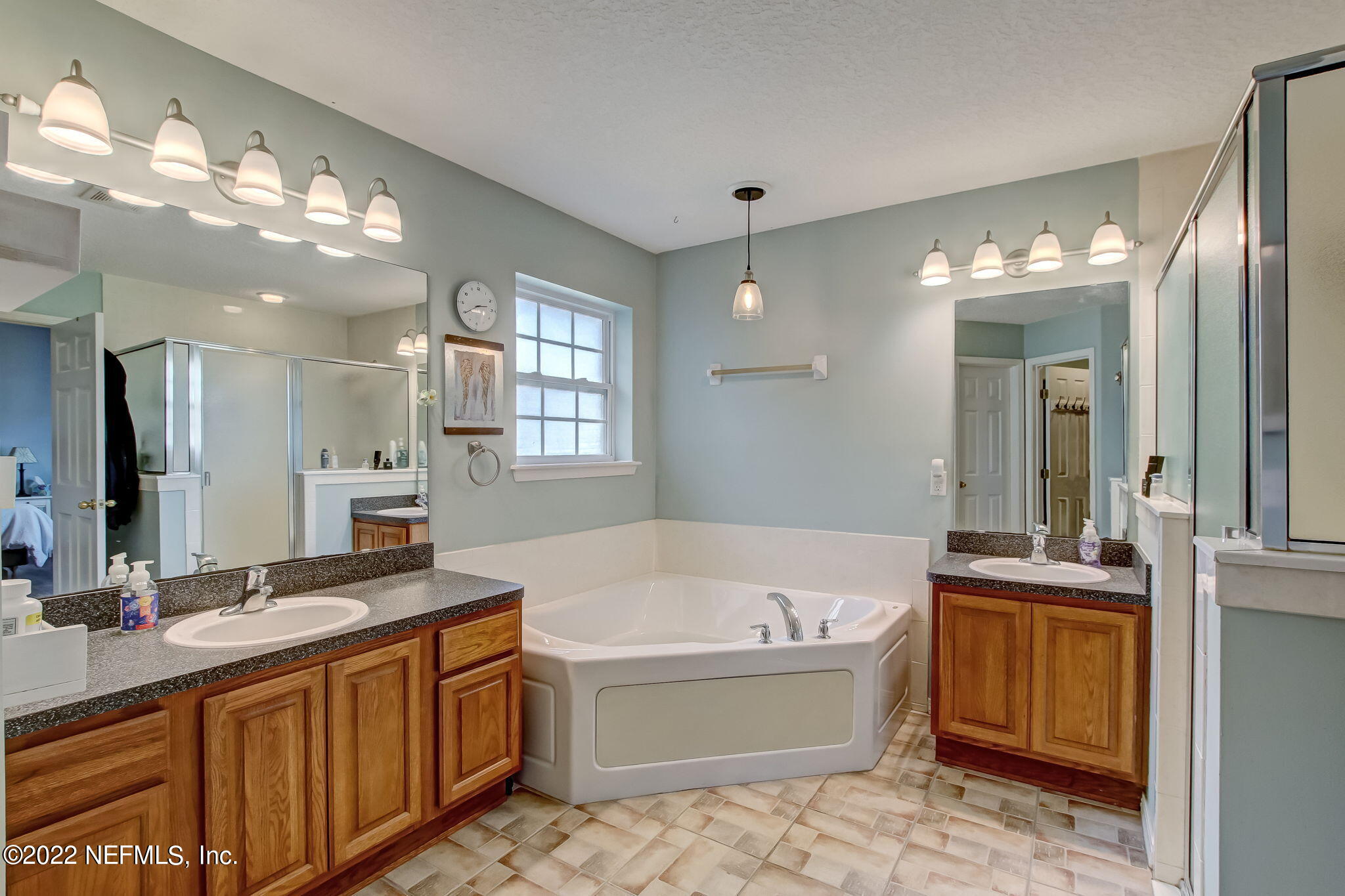 54025 Paddock Court Callahan, FL 32011 - Photo 23 of 47 a bathroom with a tub a sink double vanity and a mirror