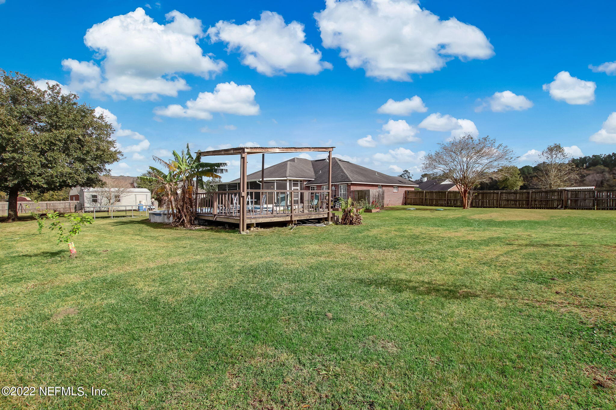 54025 Paddock Court Callahan, FL 32011 - Photo 43 of 47 a view of a big yard with flower plants and wooden fence