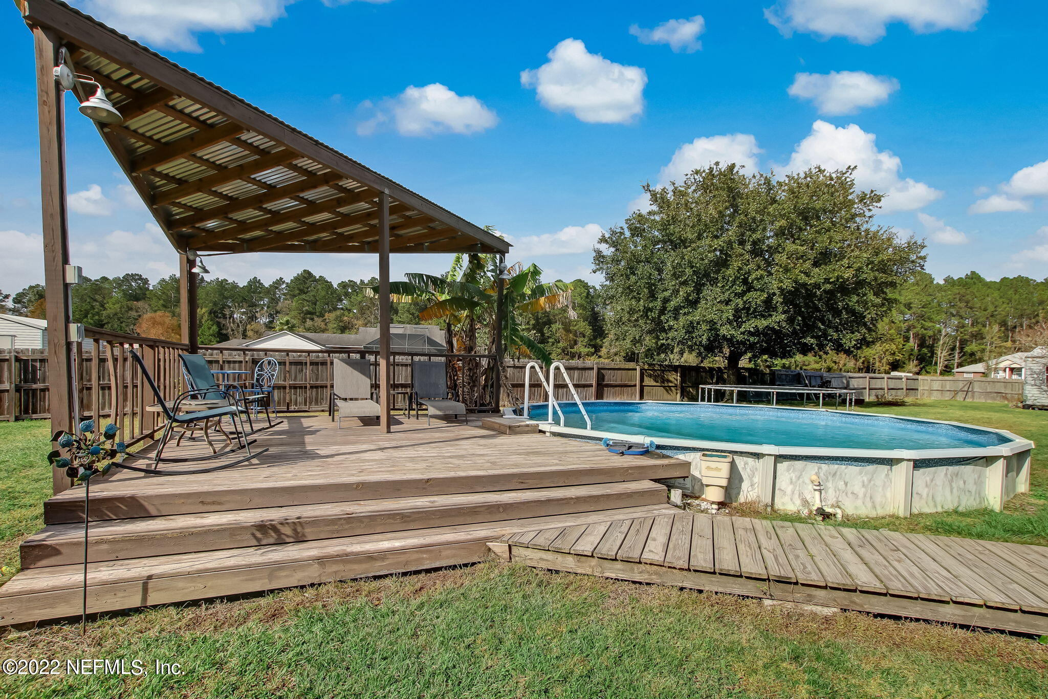 54025 Paddock Court Callahan, FL 32011 - Photo 44 of 47 a view of swimming pool with seating area and trees in the background