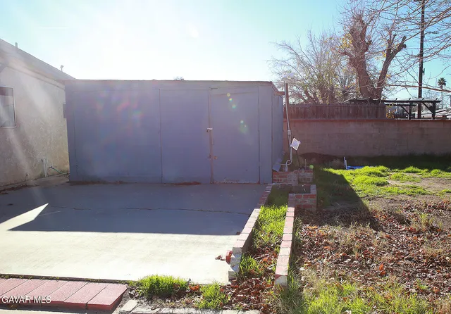 a view of a white house with a big yard and large tree