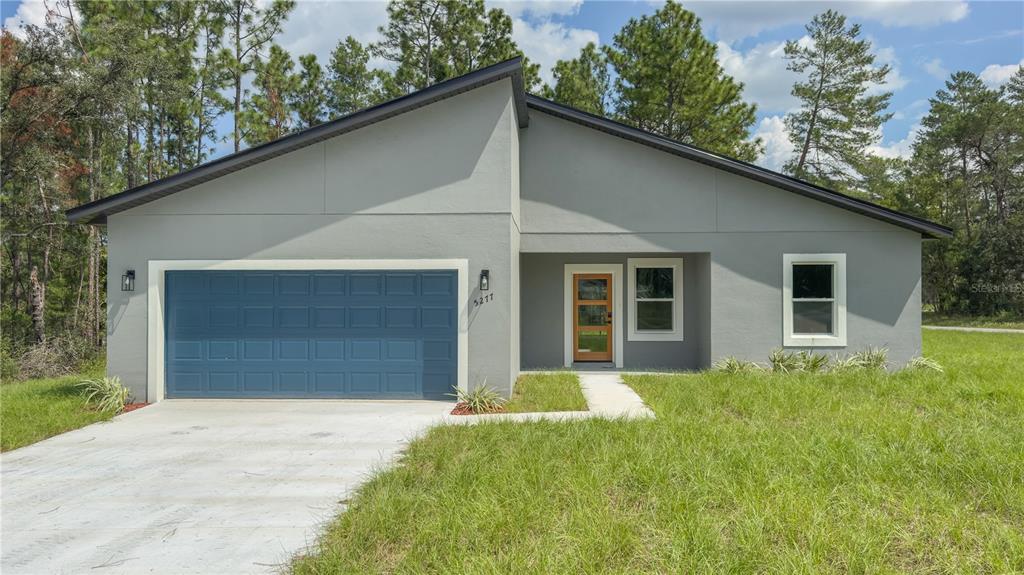 5277 Southwest 165th St Road Ocala, FL 34473 - Photo 1 of 1 a front view of a house with a yard and garage