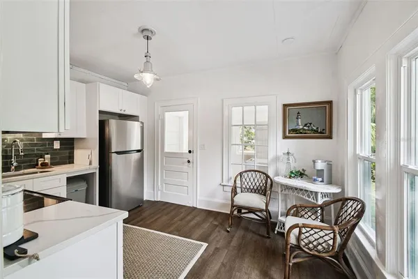 a living room with furniture and a dining table with white walls