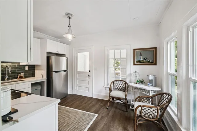 a living room with furniture and a dining table with white walls