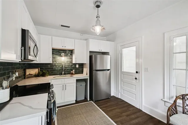 a kitchen with a refrigerator a sink and cabinets