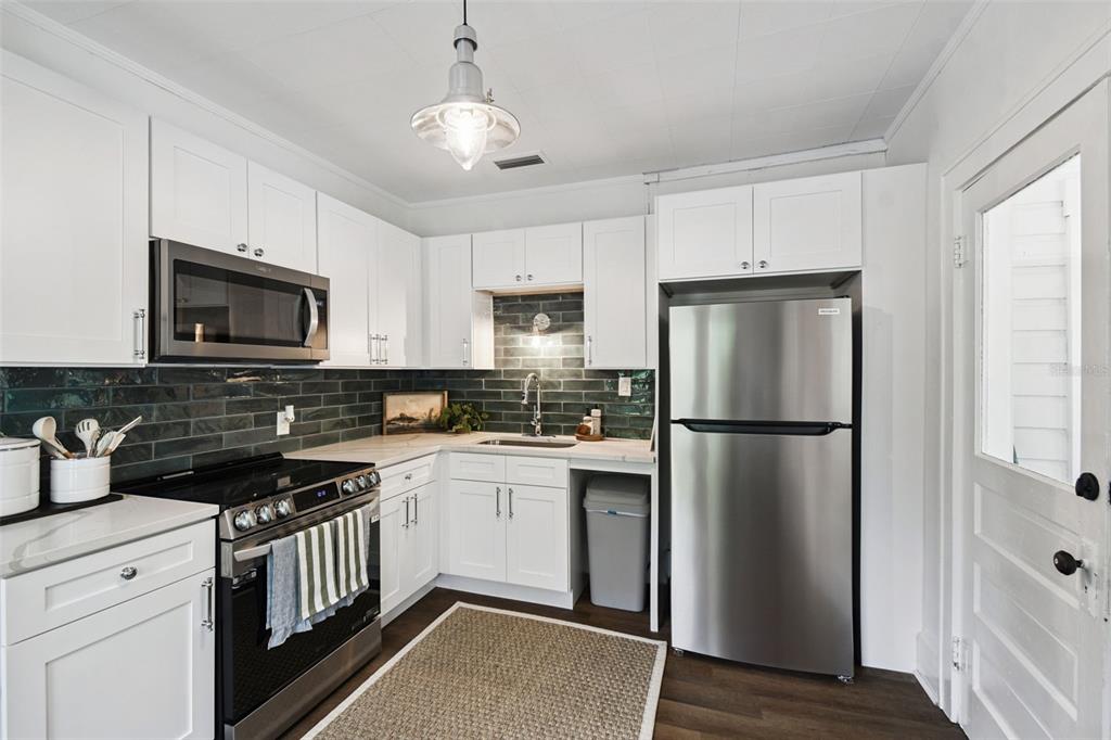 459 Bell Avenue Brooksville, FL 34601 - Photo 15 of 36 a kitchen with a refrigerator a microwave a sink and cabinets