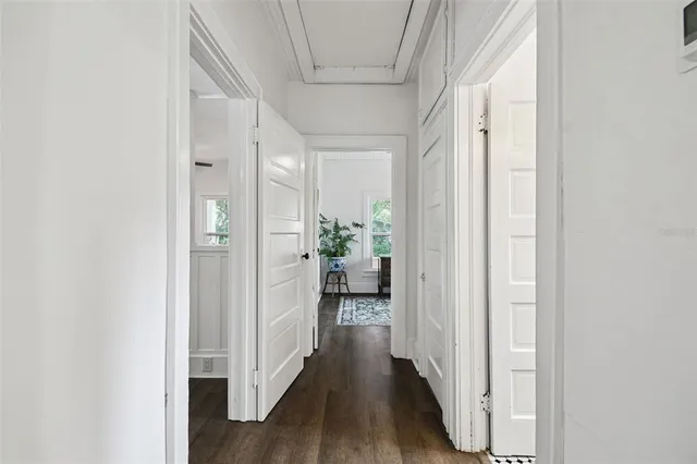 a view of a hallway with wooden floor and closet
