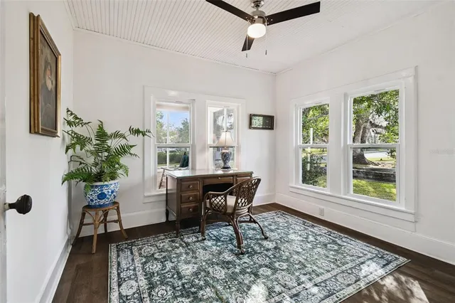 a dining room with wooden floor and a potted plant