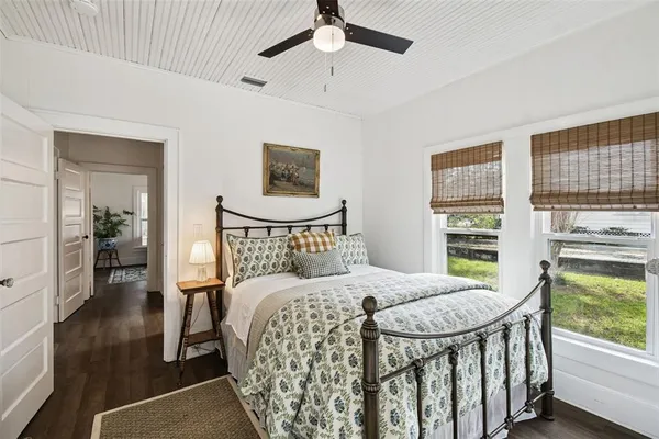 a bedroom with a bed a mirror and a window