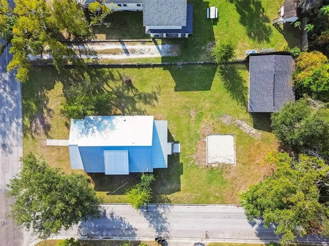 an aerial view of a house with a yard basket ball court and outdoor seating
