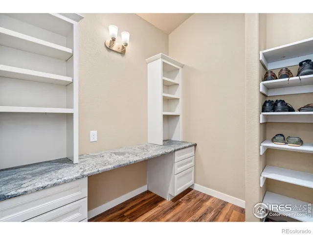 a view of walk in closet with clothes and shoes