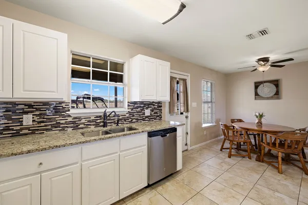 a kitchen with a table chairs and refrigerator