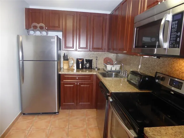 a kitchen with a refrigerator sink and cabinets