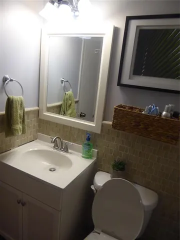 a bathroom with a sink mirror and toilet