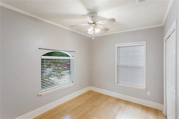 a view of an empty room with a window and wooden floor