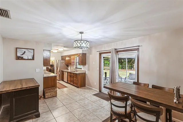 a view of a dining room with furniture a chandelier and window