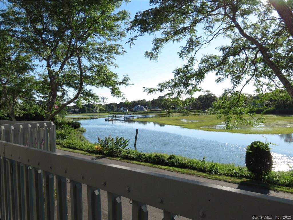 a view of a lake with a yard and outdoor seating