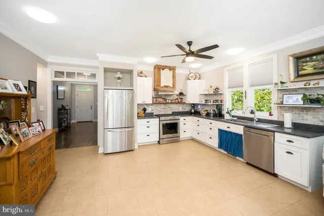 a kitchen with stainless steel appliances a stove a sink cabinets and a refrigerator